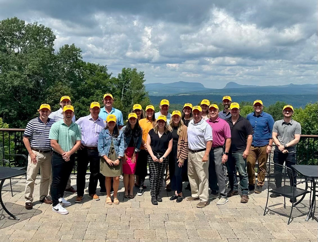 A group of people wearing yellow baseball caps