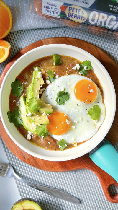 A dish of sunny-side-up eggs, avocados, and herbs pete and gerry's organic eggs