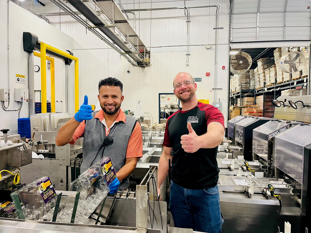 Two Pete & Gerry's workers smiling and giving thumbs-ups to the camera