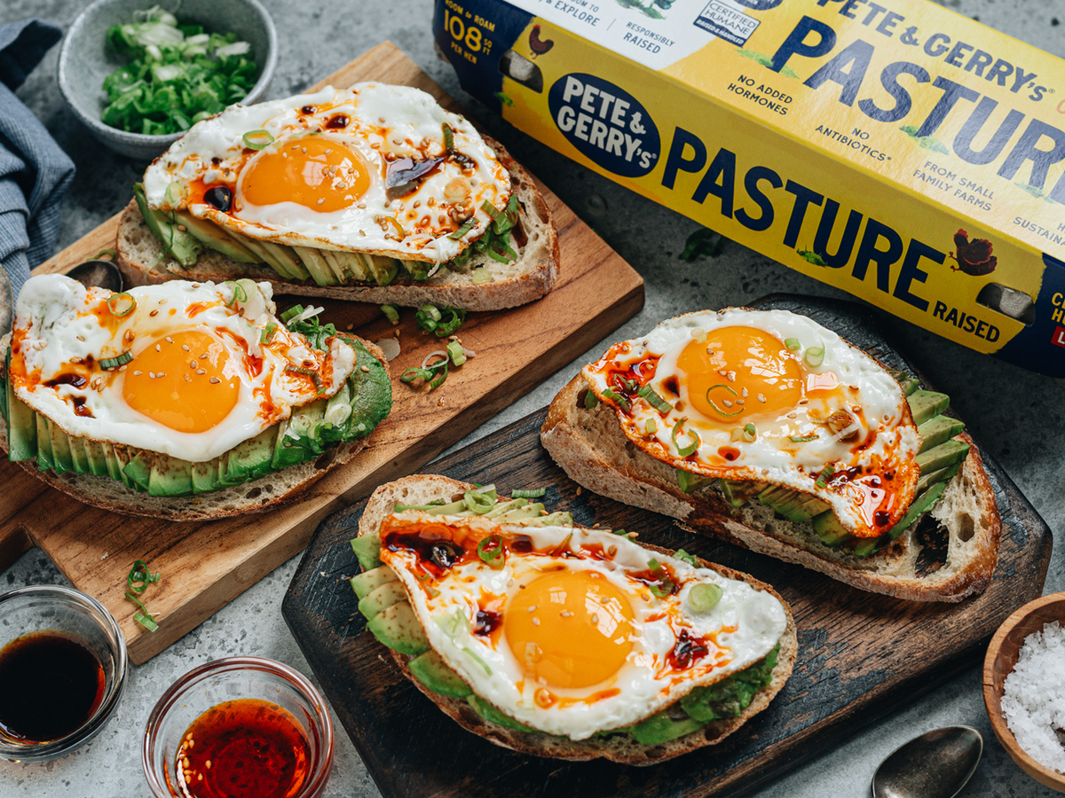 Avocado toast with a Chinese twist, featuring eggs, sliced avocado topped with chili oil with green onion and toasted sesame seeds. | peteandgerrys.com