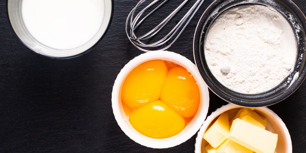 Common baking ingredients - milk, eggs, flour, and butter.
