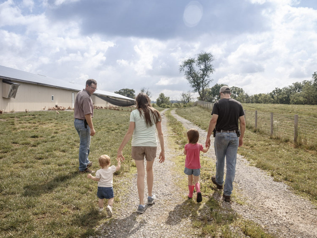 A farming family walks by their chicken coop.
