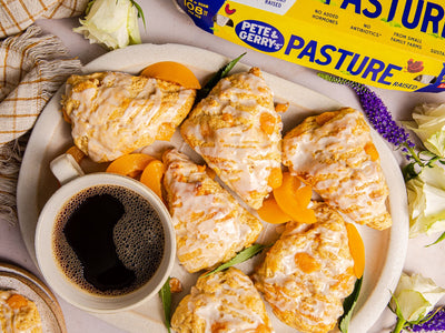 A homemade recipe for buttermilk scones made with chunks of juicy peaches and drizzled with a spiced bourbon glaze. | peteandgerrys.com