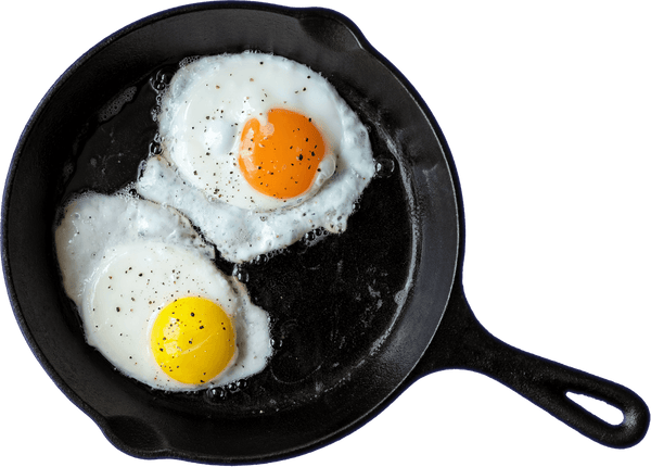 Two eggs in a pan. One with dark yellow yolks and one with brighter yellow yolks