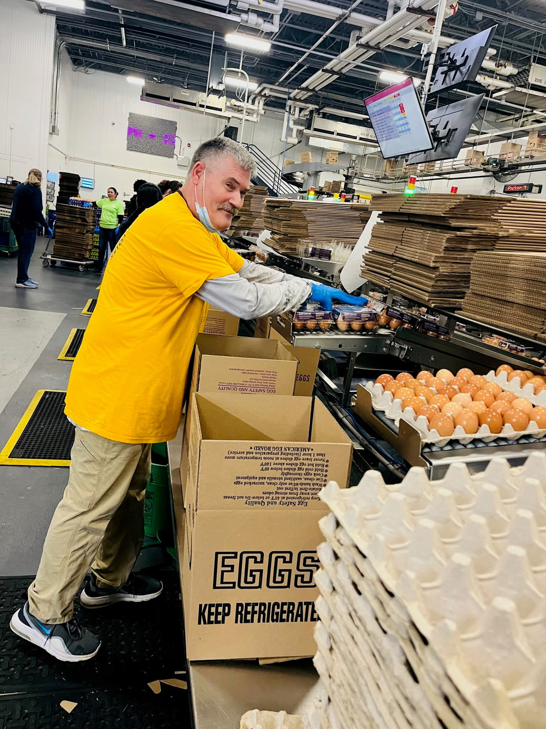 A man loading cartons of eggs in a warehouse