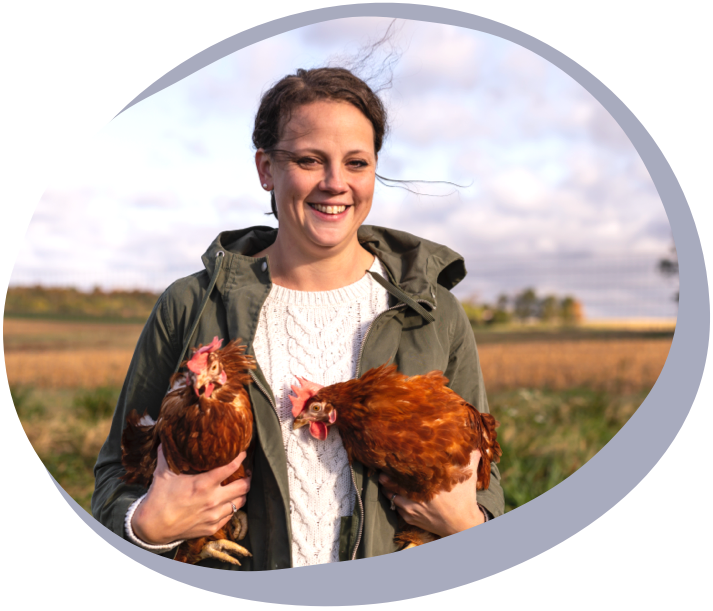 woman holding two hens outdoors pete & gerry's organic eggs